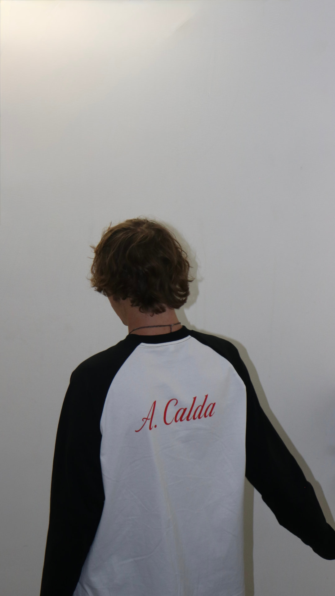 Model photographed from behind in the A. Calda raglan long sleeve